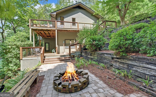 back of house featuring an outdoor fire pit, a deck, and a patio area