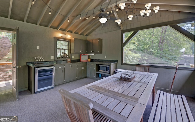 kitchen with gray cabinets, stainless steel microwave, vaulted ceiling with beams, wine cooler, and a healthy amount of sunlight