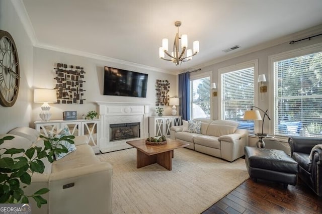 living room with crown molding, wood-type flooring, a premium fireplace, and a wealth of natural light