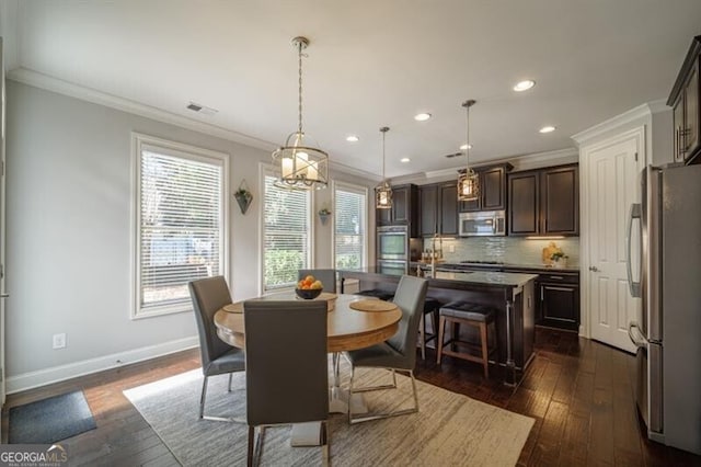 dining room with ornamental molding and dark hardwood / wood-style floors