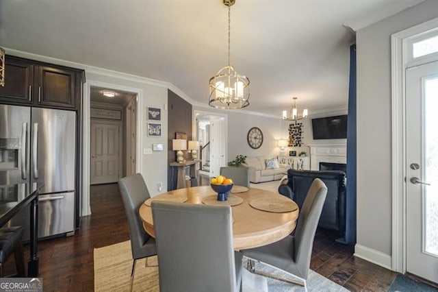 dining space with ornamental molding, dark wood-type flooring, and a notable chandelier