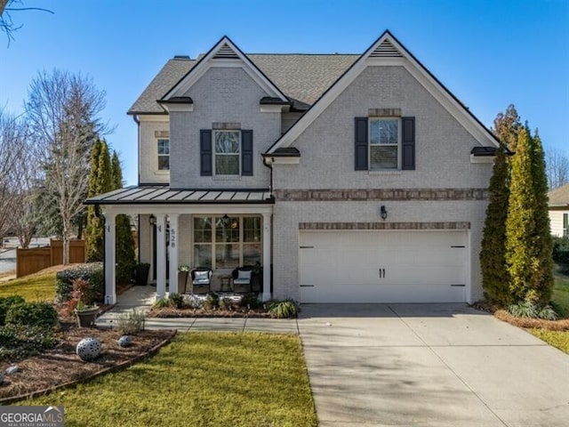 view of front of house featuring a garage, a front yard, and a porch