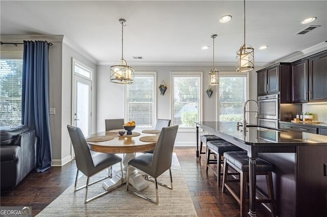 dining space with ornamental molding, dark hardwood / wood-style flooring, and sink