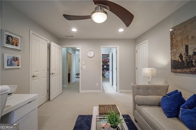 interior space with ceiling fan and light colored carpet