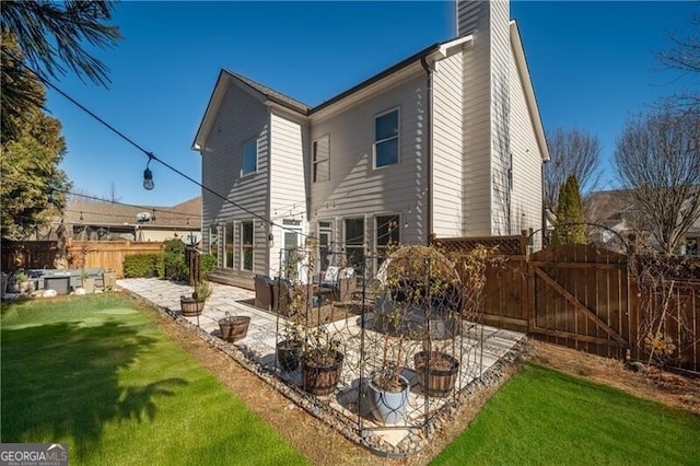 back of house with a yard and a patio