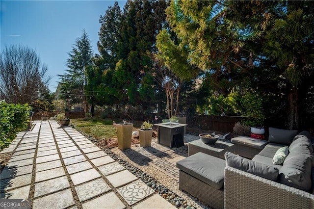 view of patio with an outdoor living space with a fire pit