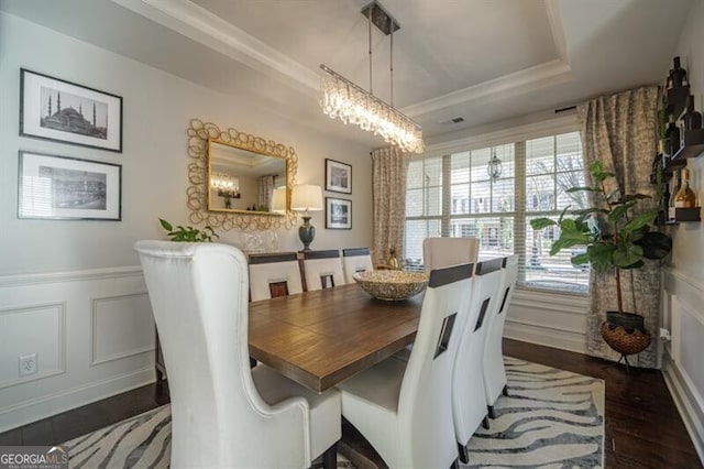 dining room featuring dark hardwood / wood-style flooring and a tray ceiling