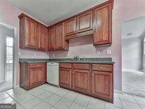 kitchen featuring light tile patterned floors, sink, and dishwasher