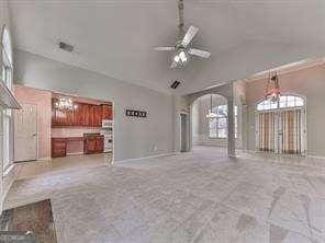 unfurnished living room with ceiling fan