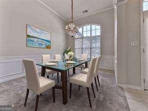 dining room with ornamental molding and a chandelier