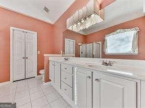 bathroom featuring crown molding, vanity, tile patterned flooring, and walk in shower