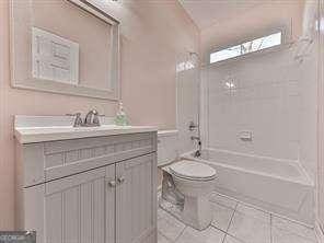 full bathroom with vanity, tile patterned floors, toilet, and tiled shower / bath