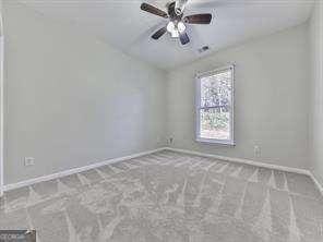 carpeted empty room featuring ceiling fan