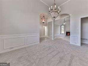 spare room featuring crown molding and a notable chandelier