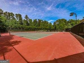 view of tennis court with basketball hoop