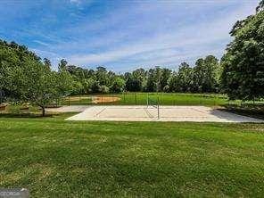 view of community featuring a lawn and volleyball court