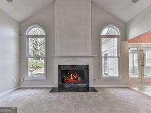 unfurnished living room featuring vaulted ceiling, carpet, and a large fireplace