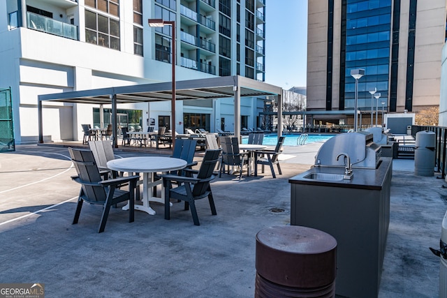 view of patio with area for grilling and a community pool