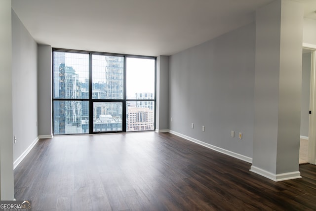 unfurnished room with dark wood-type flooring and floor to ceiling windows