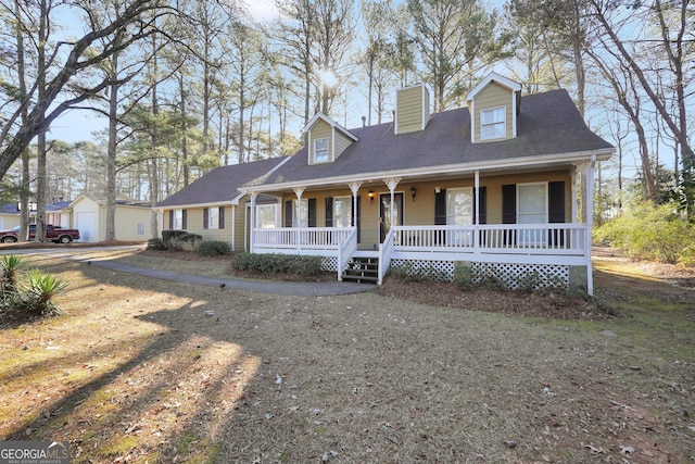 cape cod house with a garage and covered porch