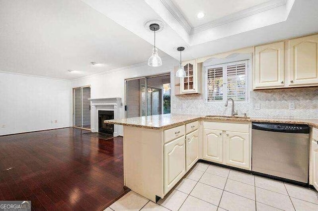 kitchen featuring light tile patterned flooring, sink, decorative light fixtures, dishwasher, and a raised ceiling