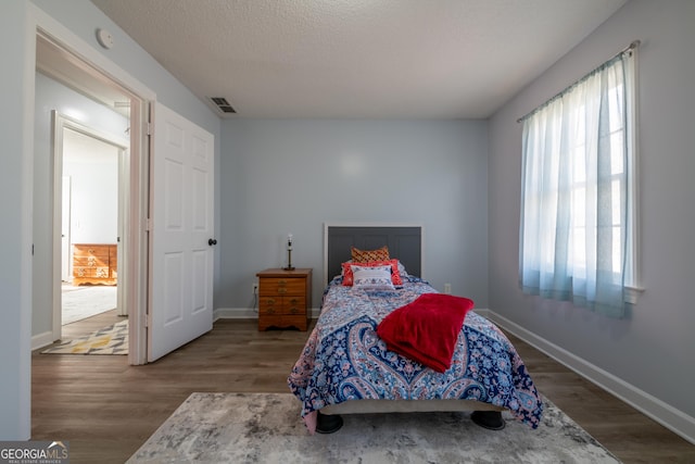 bedroom with wood-type flooring and a textured ceiling