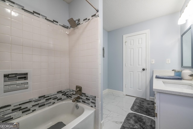 bathroom featuring tiled shower / bath combo, vanity, and a textured ceiling