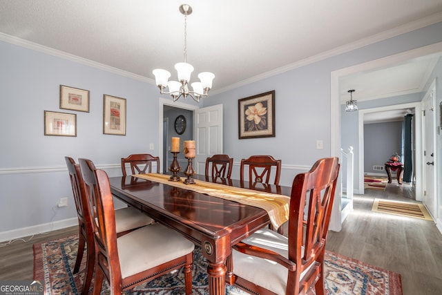 dining area featuring ornamental molding, dark hardwood / wood-style flooring, and a notable chandelier