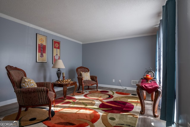 sitting room featuring crown molding, wood-type flooring, and a textured ceiling