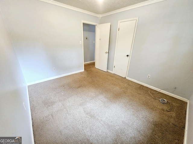 empty room with crown molding, a textured ceiling, and carpet flooring