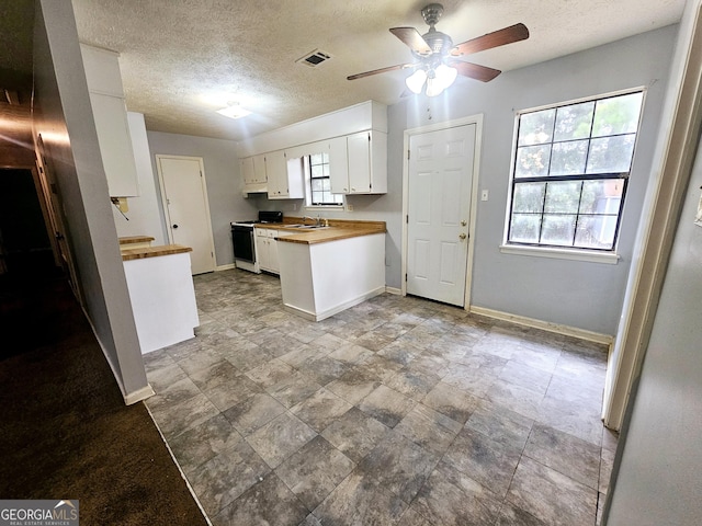 kitchen with sink, white cabinets, ceiling fan, white range with electric cooktop, and a textured ceiling