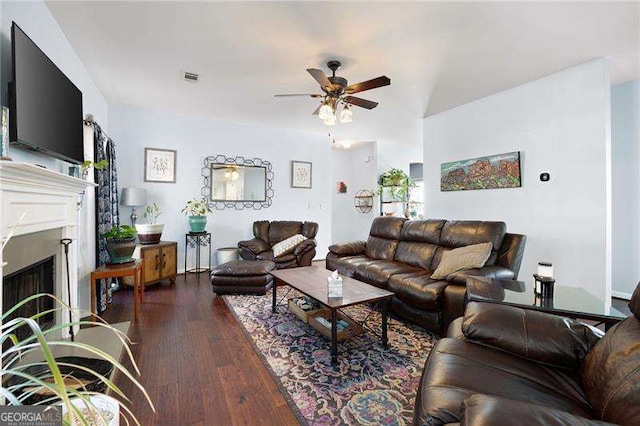 living room with ceiling fan and dark hardwood / wood-style flooring