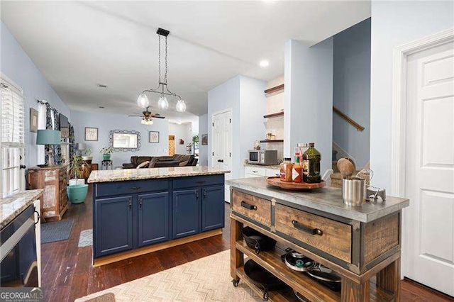 kitchen with dark wood-type flooring, blue cabinetry, a kitchen island, pendant lighting, and ceiling fan