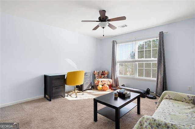 living area featuring light carpet and ceiling fan