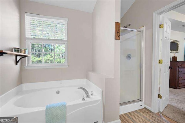 bathroom featuring lofted ceiling, plenty of natural light, and shower with separate bathtub