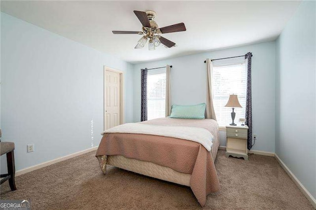 carpeted bedroom with multiple windows and ceiling fan