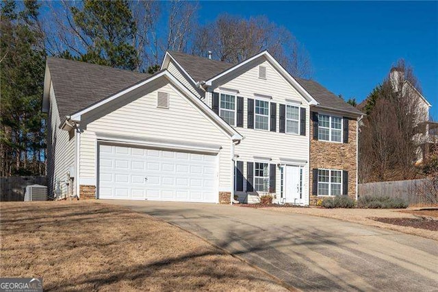 view of front of house featuring central AC, a garage, and a front yard