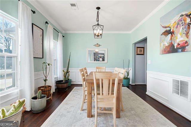 dining space with ornamental molding, dark hardwood / wood-style floors, and a notable chandelier