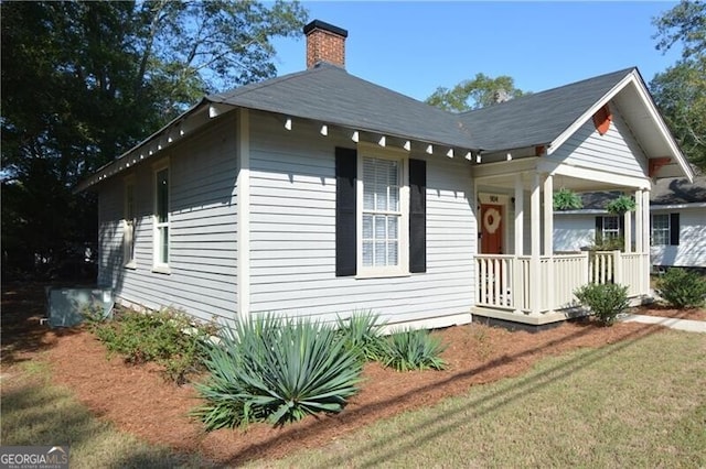 view of property exterior with a yard and covered porch