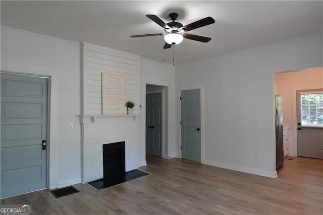 unfurnished living room featuring light hardwood / wood-style flooring, a fireplace, and ceiling fan