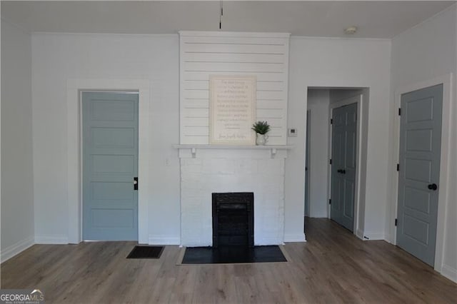 unfurnished living room featuring wood-type flooring and a fireplace