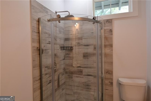 bathroom featuring walk in shower and toilet