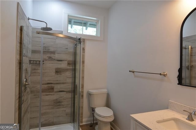 bathroom featuring walk in shower, vanity, and toilet