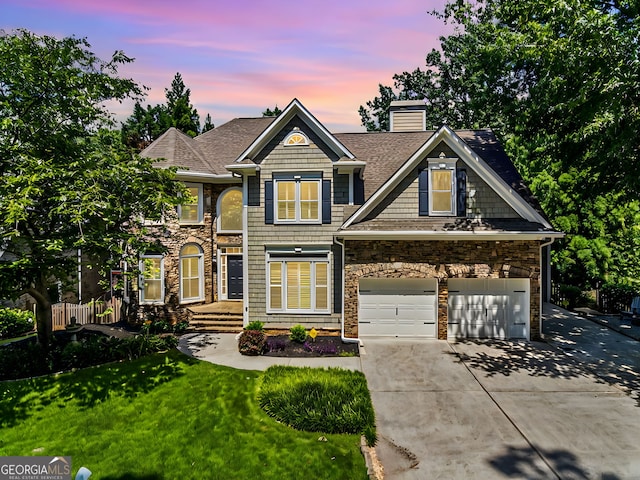 craftsman inspired home with a garage and a lawn