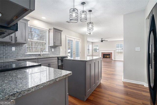 unfurnished living room with dark wood-type flooring and ceiling fan with notable chandelier