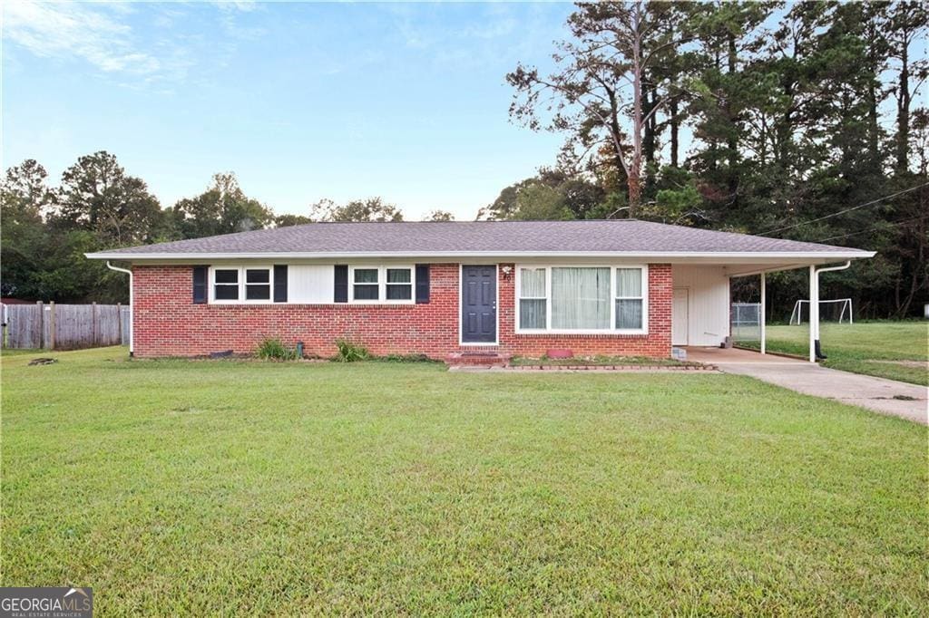 ranch-style house with a front yard and a carport