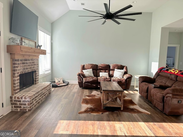 living room featuring dark hardwood / wood-style flooring, a fireplace, ceiling fan, and vaulted ceiling