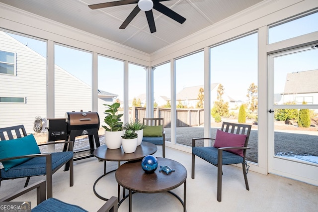 sunroom / solarium featuring a wealth of natural light, a ceiling fan, and carpet