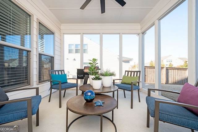 sunroom with carpet flooring, a ceiling fan, and ornamental molding
