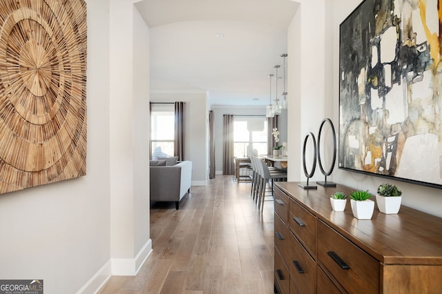 corridor with wood finished floors and baseboards